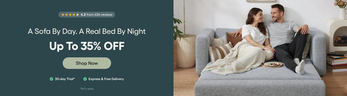 Promotional banner for a sofa bed offer, featuring a man and woman lying on a gray upholstered sofa bed in a living room setting, alongside marketing text on a dark teal background.