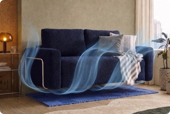 A navy blue upholstered sofa in a modern living room setting, with decorative pillows and a striped throw blanket, plus blue airflow-like graphics suggesting ventilation or cooling.