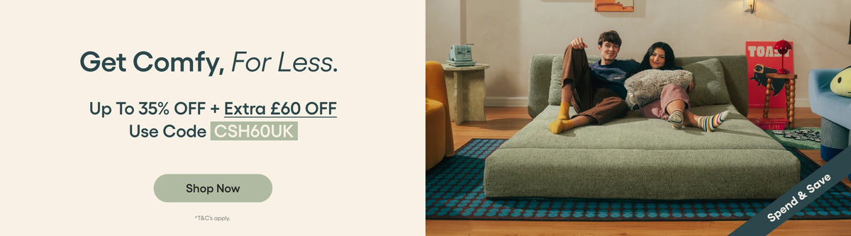 Promotional banner for a sofa, featuring a couple lounging on a light green upholstered sofa in a living room setting. The left side contains promotional text reading 'Get Comfy, For Less.